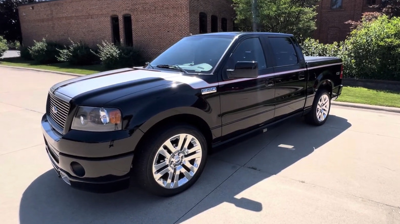 a distinctive Ford F-150 sits parked outside with eye-catching wheels and a stripe running from hood to tail.
