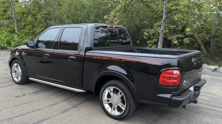 A black Ford F-150 Harley-Davidson Edition sits parked with an abundance of quirks and features, including orange flame details. .
