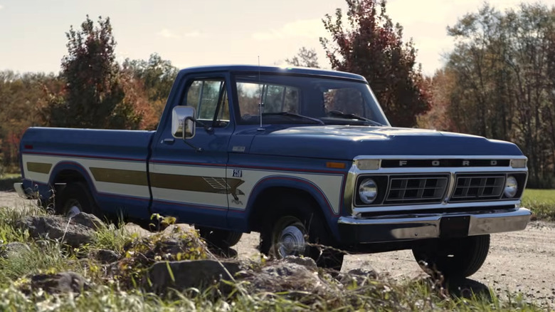 1976 Ford F-250 Bicentennial truck parked along a dirt road.
