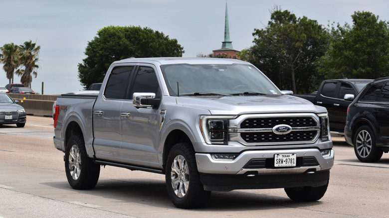 A gray Ford F-150 pick-up truck traveling down a highway in moderate traffic