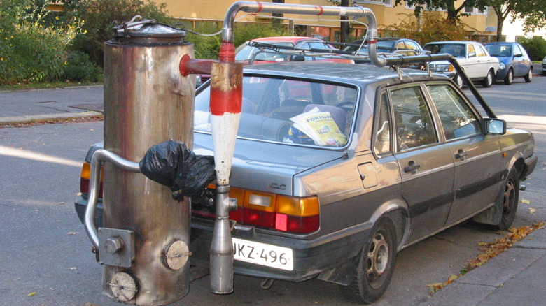 A wood gas unit attached to a gray car parked on the street in Helsinki, Finland
