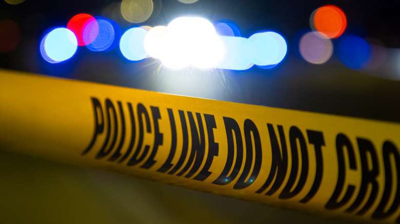 Police tape and flashing lights in response to a car crash
