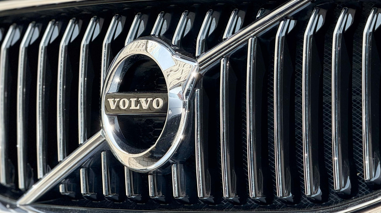 A close-up of the Volvo logo across the front grille of one of the automaker's cars.