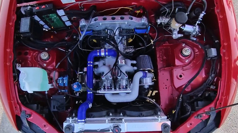 An INNengine 500cc e-Rex installed in a red Mazda Miata with a view directly above the engine with the hood open