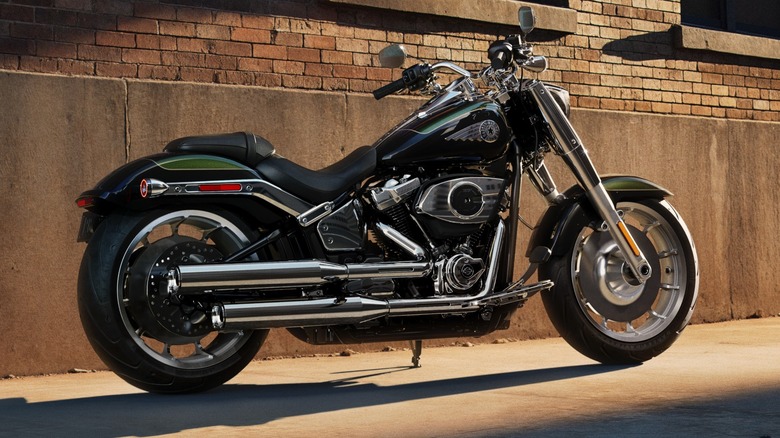A Harley-Davidson Fat Boy parked on an urban sidewalk in front of a brick building