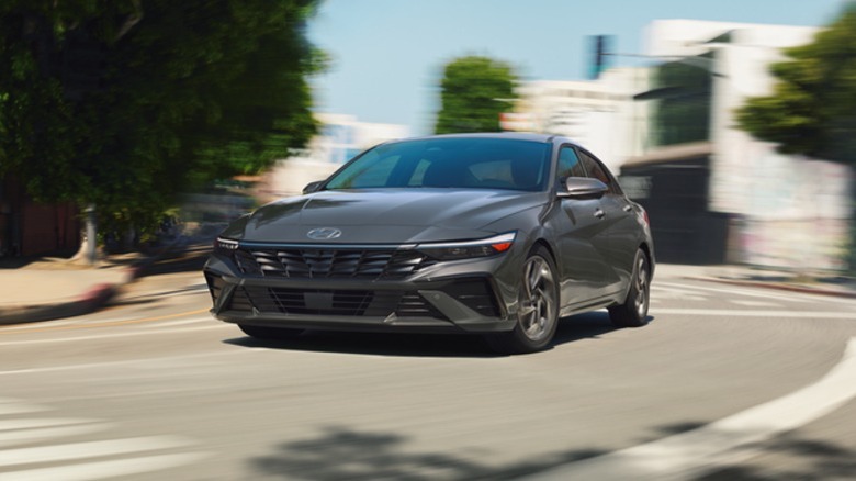 A dark metallic grey 2026 Hyundai Elantra Hybrid sedan taking a corner.