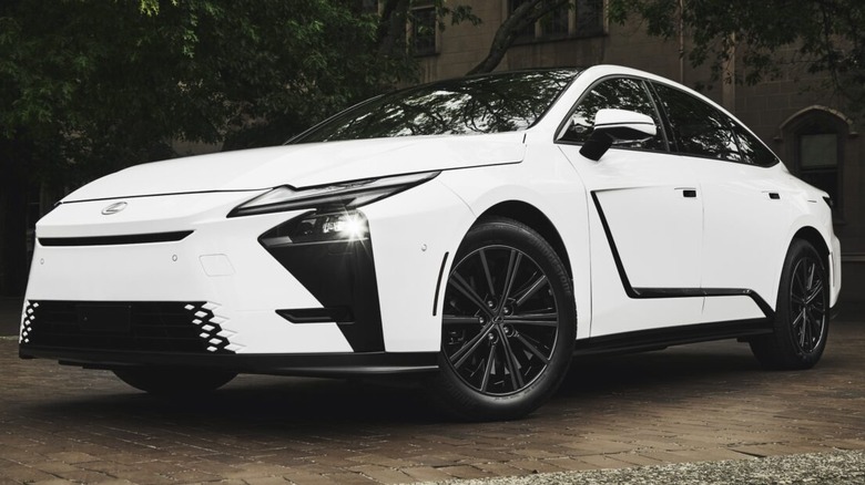A white 2026 Lexus ES 350h luxury sedan featuring dark multi-spoke wheels and sharp, angular black aerodynamic trim panels on the front bumper.