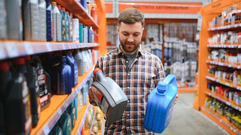 A person choosing between two engine oils