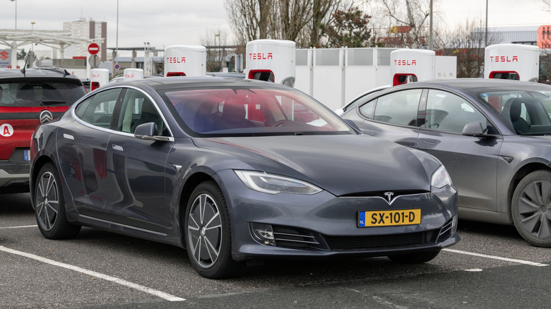 A tesla in charging at a Tesla charger in a parking lot in France