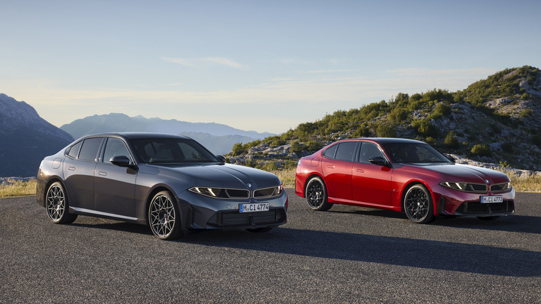 Front 3/4 view of a gray 2027 BMW 330 and a red 2027 BMW M350