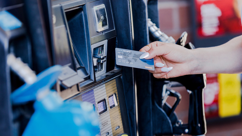 Stock image of a person paying for gas with a bank card.