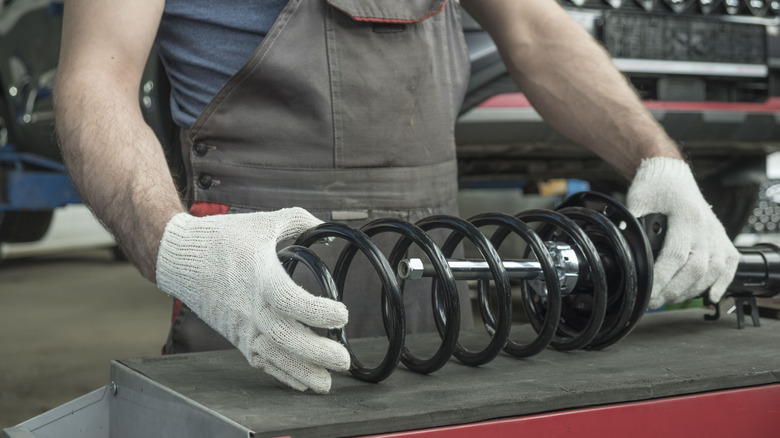 A mechanic servicing the shocks and struts of a vehicle