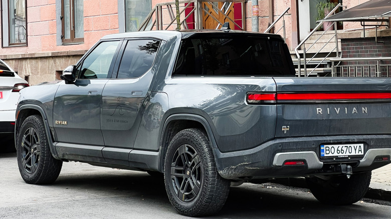 Kyiv, Ukraine - November 10, 2025: A gray Rivian R1T pickup sits parked on a city street beside a residential building.