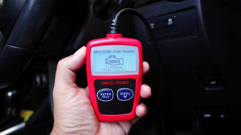 An OBD-II code reader plugged into a car's OBD-II port