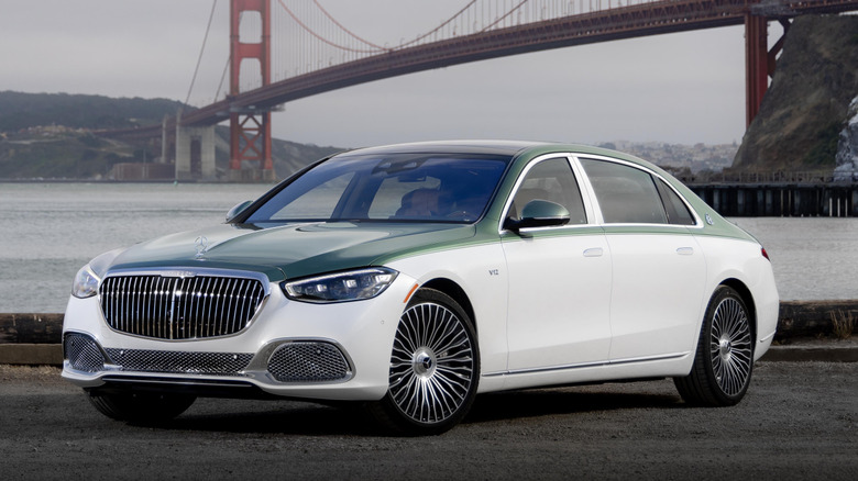 A front three-quarters shot of a two-tone light green over white S680 parked in a lot in front of the Golden Gate Bridge on a gray day