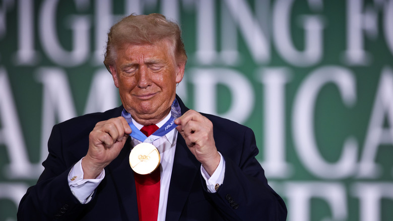 CHIPPEWA FALLS, WISCONSIN - JUNE 05: U.S. President Donald Trump wears the Olympic gold medal of Team USA speedskater Jordan Stolz during a roundtable on agriculture at Custer Farms on June 05, 2026 in Chippewa Falls, Wisconsin. President Trump delivered remarks on his administration's agricultural policies and efforts to support farmers. (Photo by Samuel Corum/Getty Images)