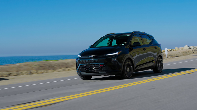 Front 3/4 view of a black 2027 Chevrolet Bolt in motion.