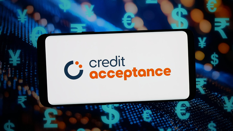 In this photo illustration, the logo of US auto finance company Credit Acceptance is displayed on a smartphone in front of abstract background on computer screen.