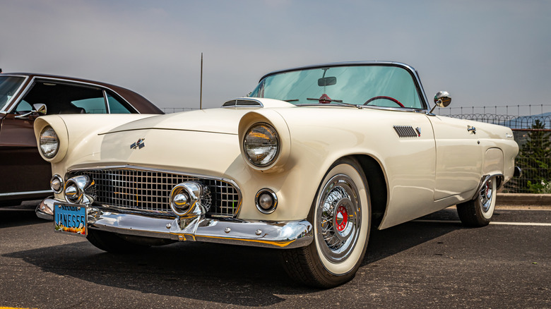 A white 1955 Ford Thunderbird convertible parked at a car show