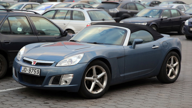 A blue-gray Saturn Sky in a car park in Eastern Europe
