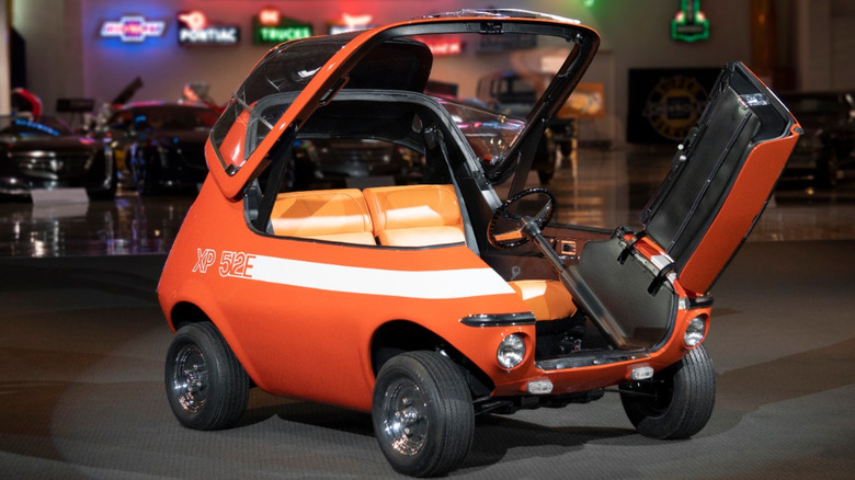 The orange 1969 XP 512E electric vehicle in the GM Heritage collection with its canopy and front door open