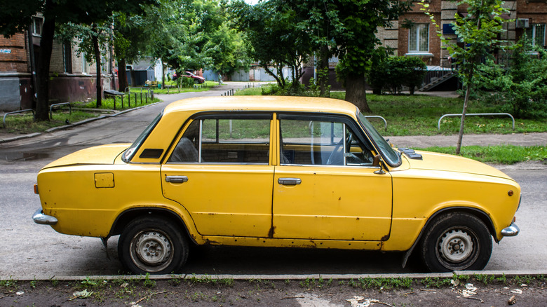A rusty old lada parked in Russia