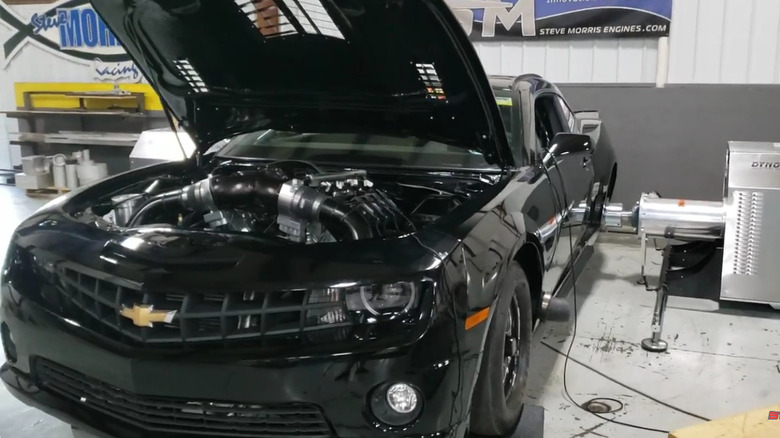 A modified black Chevrolet Camaro attached to a wheel-hub dyno