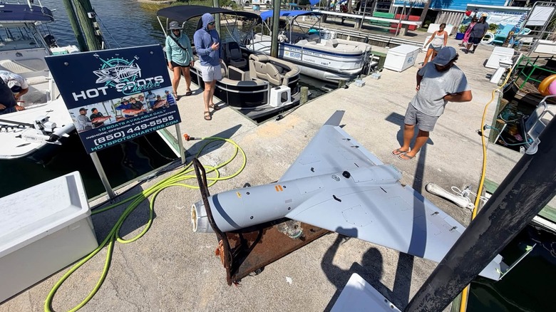A damaged LUCAS drone sitting on the dock next to a Hot Spots Charters sign