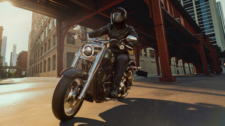 A rider and 2026 Harley-Davidson Fat Boy cruising through a city