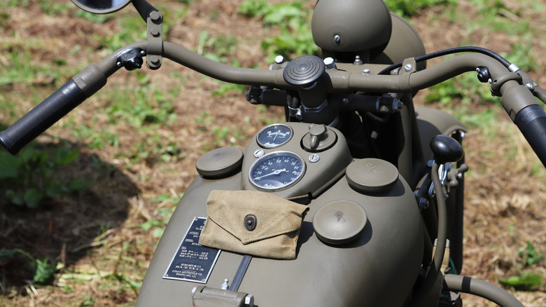 A historic Indian World War II US Army motorcycle is parked out of a meadow