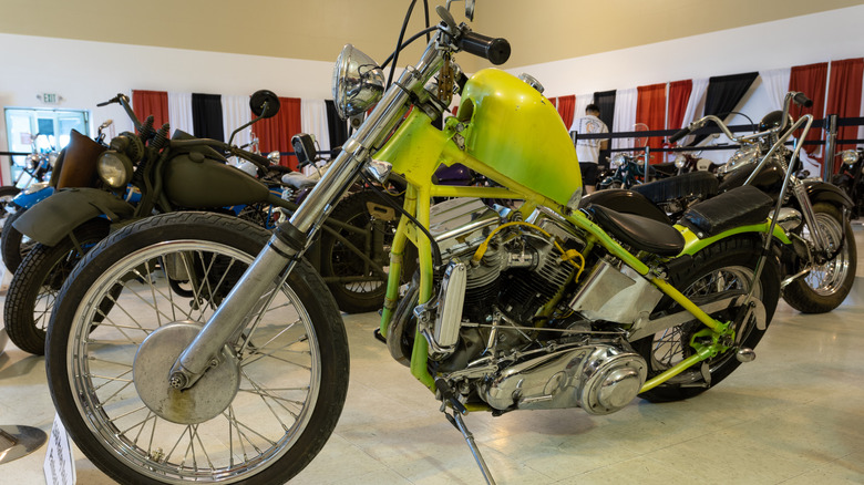 A 1948 Harley Davidson Panhead Chopper like green motorcycle at a show.