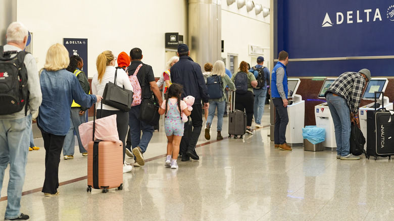 Travelers wait in long lines early in the morning of March 27, 2026 at Atlanta Hartsfield-Jackson International Airport.