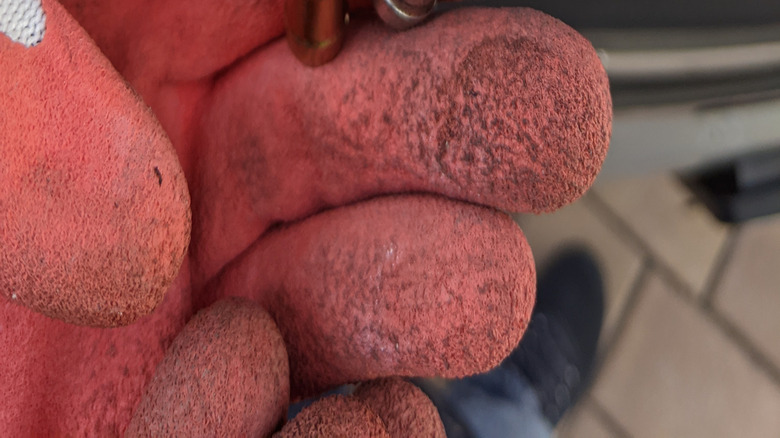 Mechanic holding a new PCV valve (left) and an old one (right)