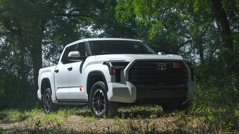 A white 2026 Toyota Tundra in front of trees.