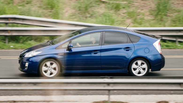A blue Toyota Prius being driven on the highway