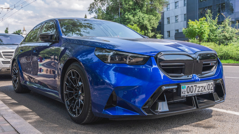An electric blue BMW M5 Plug-in hybrid car parked on the road