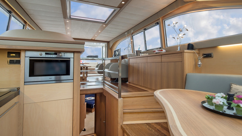 The interior of a yacht's cabin with an oven visible and several lights illuminated