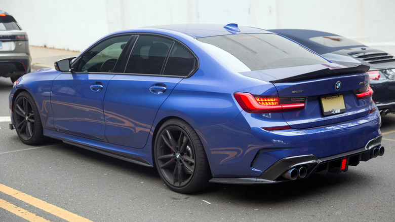 The rear 3/4 shot of a blue 2021 BMW M340i xDrive with a carbon rear diffuser and quad exhausts