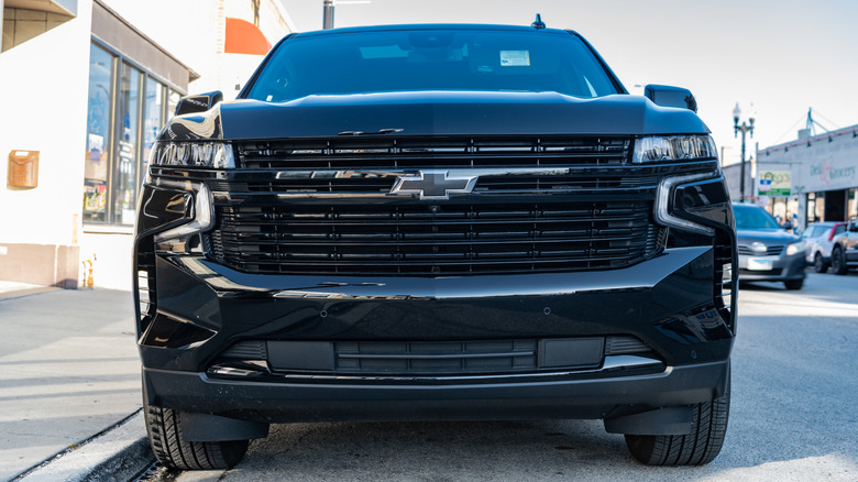 A front-end close-up shot of a black Chevy Tahoe parked outside.