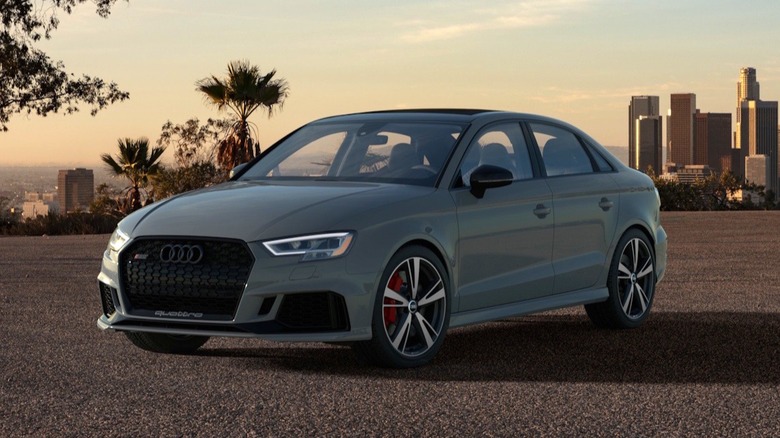 A gray 2020 Audi RS3 in front of a city skyline.