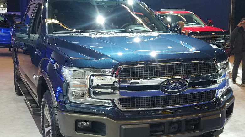 A blue 2020 Ford F-150 Platinum on display at an auto show.