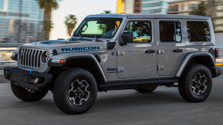 2021 Jeep Wrangler Rubicon 4xe driving on a paved road with buildings in the background