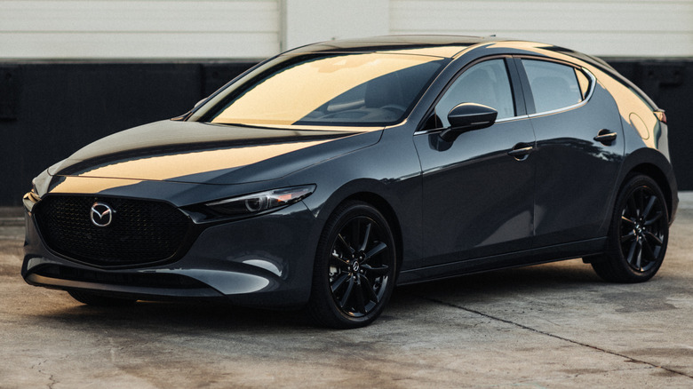 2020 Mazda3 Hatchback parked on a concrete surface in front of a large building