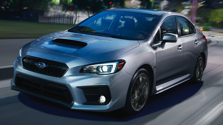 Gray 2020 Subaru WRX driving down city street with buildings in the background
