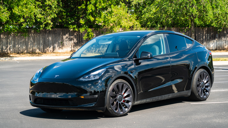 A black Tesla Model Y in a parking lot.