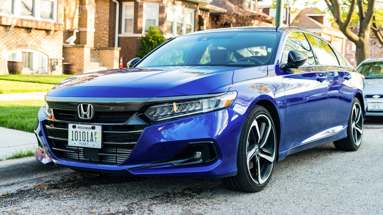 A blue 2020 Honda Accord parked by a sidewalk