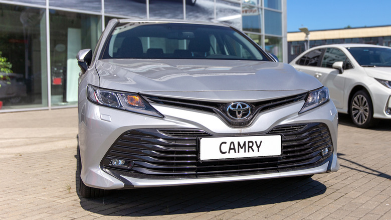 A silver Toyota Camry parked outside of a dealership