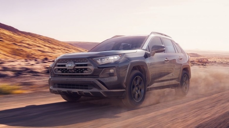 A gray 2020 Toyota RAV4 being driven on an unpaved road.
