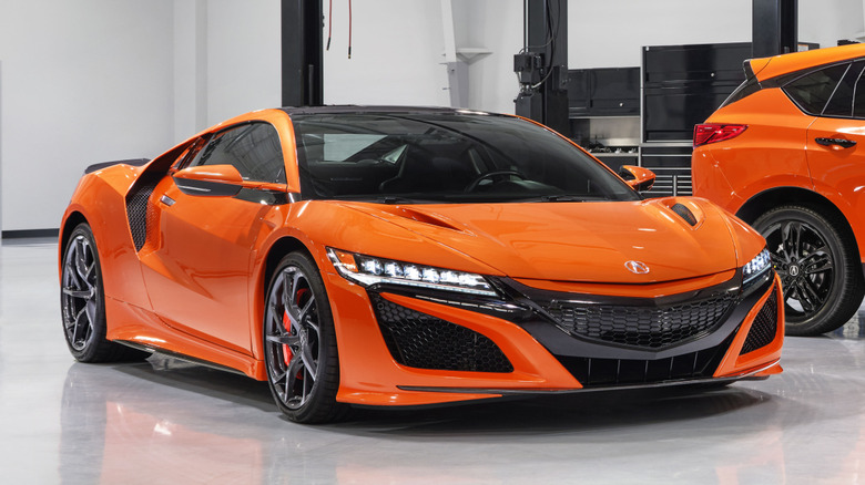 An orange 2021 Acura NSX inside a garage.