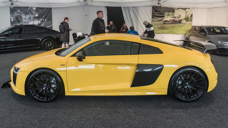 A side profile view of a yellow Audi R8 parked on display.